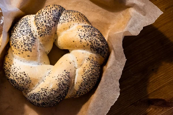Bun in a basket on parchment. The basket is on a wooden table