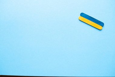 wooden sticks in the colors of the flag of ukraine on a blue background. Ukraine flag on a blue background, space for text. Ukraine's Independence Day. Wooden sticks. Ukrainian flag