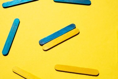 Colored sticks on a yellow background. Blue and yellow colors. Ukrainian flag