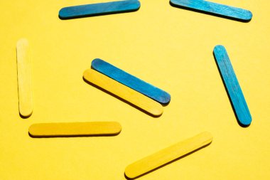Colored sticks on a yellow background. Ukrainian flag