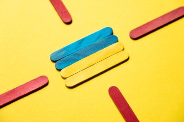 Flag of ukraine at gunpoint from red sticks close-up