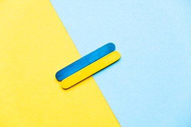 flag of ukraine from wooden sticks on a blue and yellow background