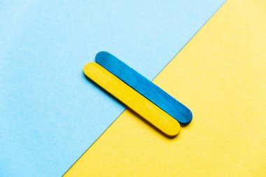 flag of ukraine from wooden sticks on a blue and yellow background. united ukraine