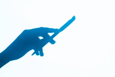 shadow hand holding a pen, free space. Place for text