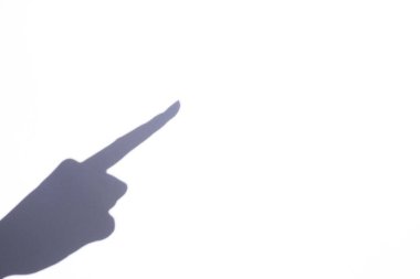 Gestures. The shadow of a woman's hand points to free space with a finger. Place for text.