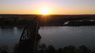 Bismarck Kuzey Dakota 'da gün batımında Missouri Nehri' ni kaplayan eski demiryolu köprüsünün hava manzarası..