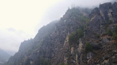 Bulutlu bir günde Nepal 'deki Annapurna sıradağlarında dağ yamaçlarında uçmak.