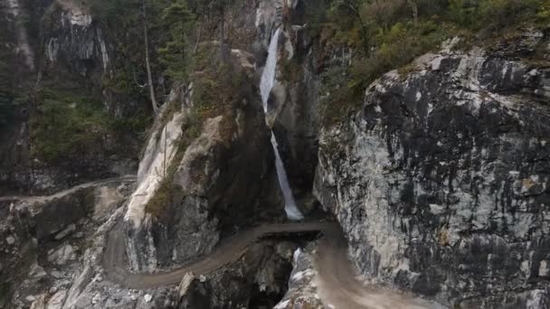 산맥의 절벽에 구불구불 비포장도로를 폭포를 날아오는 — 비디오