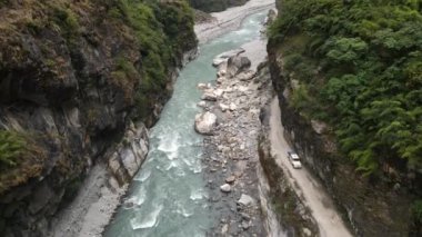 Marsyangdi Nehri 'ne doğru uçarken Annapurna Dağları' ndaki kanyon duvarını kesen araç toprak yolda ilerliyor..