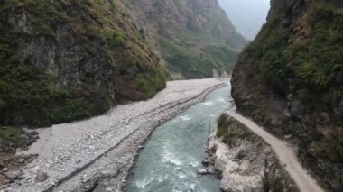 Nepal 'deki dağların arasından akan kanyon kayalık duvarına oyulmuş toprak yolu olan Marsyangdi Nehri..