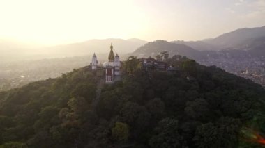 Circling around Swayambhunath Stupa in Kathmandu Nepal on a hill surrounded by trees.