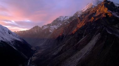 Kyanjin Vadisi 'ndeki Nepal' deki dağların üzerinde parlayan güneşin hava manzarası.