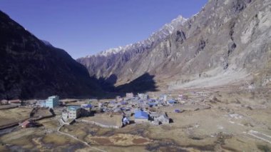 Langtang Nepal 'de mavi çatıları olan köyün üzerinde uçmak, dağları görmek..