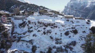 Himalayalar 'da karla kaplı Ngawal Köyü' nün havadan görünüşü binalara bakıyor..