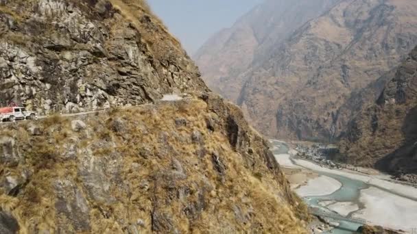 沿着Marsyangdi河沿路开进山坡的卡车在尼泊尔的峡谷中穿行 — 图库视频影像