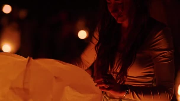 Νεαρή Γυναίκα Εκτοξεύει Ένα Χάρτινο Φανάρι Μέσα Στη Νύχτα Χαμογελώντας — Αρχείο Βίντεο