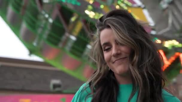 Mujer Joven Sonriendo Posando Para Cámara Frente Paseo Carnaval Girando — Vídeo de stock