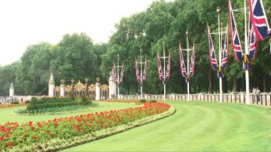 Park çevresinde bir çim çiçekli Green Park Londra, İngiltere, altın ve siyah Kanada Gate yakınındaki bayraklı.