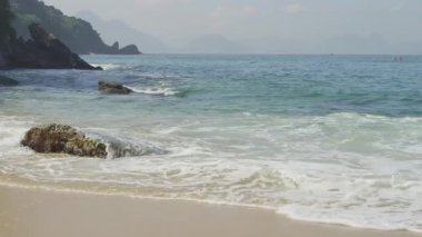 Ağır çekim bir kaya Rio'nun Red Beach çevresinde swirling dalgaların