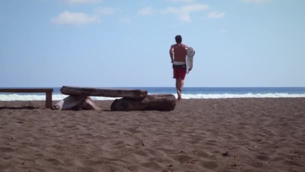Λευκό Αρσενικό Surfer Βήματα Από Driftwood Τρέχει Μακριά Από Την — Αρχείο Βίντεο