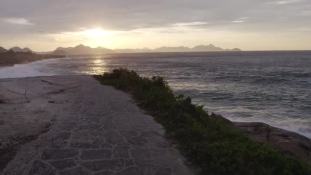 Câmera Move Longo Caminho Pedra Com Sol Nascendo Sobre Praia — Vídeo de Stock