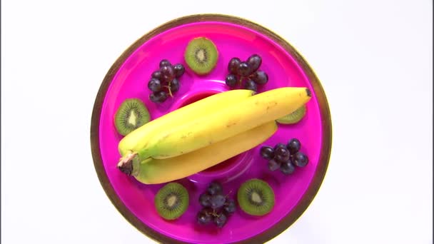 白い画面で回転皿の上の果物の品揃えの広いショット — ストック動画