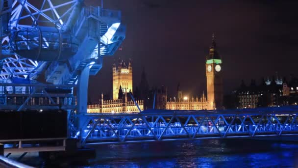 ロンドン アイ観覧車で夜のビッグ ベンと国会議事堂のタイムラプス 青い光で照らされ 前景に — ストック動画