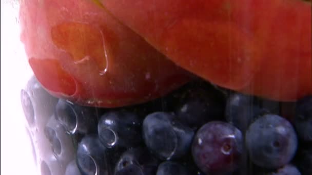 倾斜而下拍摄的各种各样的水果在一个白色的屏幕上的一个花瓶 — 图库视频影像