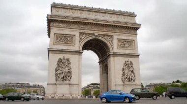 Zaman hata onlar hızlı bir şekilde sokak daire geçerken araba ve otobüs bu ünlü, tarihi, süslü Arc de Triumph, turist altındaki, Paris, Fransa için meşgul, bulutlu bir günde çevreleyen.