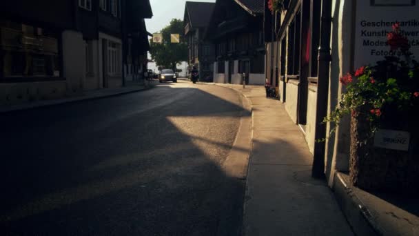 브리엔츠 Brienz 불리는 스위스 마을의 도로의 태양이 떨어지면서 자동차는 그림자 — 비디오