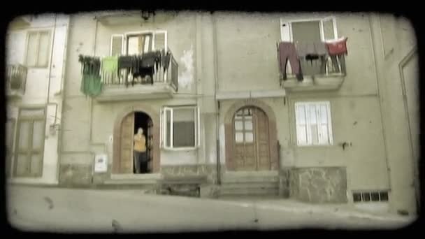 中イタリア都市に戻る前に彼の家の玄関に出てくる男のショット ビンテージの様式化されたビデオ クリップ — ストック動画