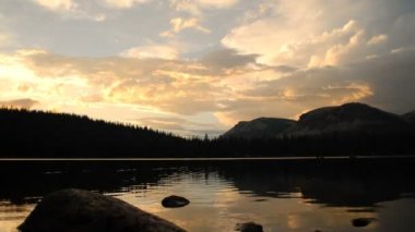 Geniş timelapse silhouette dağ Gölü ve günbatımı bulutlara