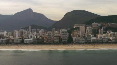 Rio de Janiero'nun plajlarından birinin havadan veiw'i. Kıyılar, dağlar ve şehir şeridi görülebilir.