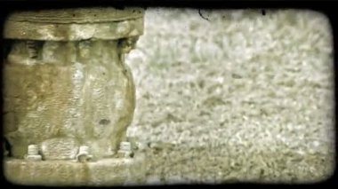 Kayalık su havuzunda oturan paslı zincirle sarılmış kontrol tekerleğine cıvatalarla bağlanan eski paslama kontrol borusunun yavaş tavası. Vintage stilize video klip.