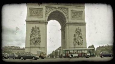 Paris, Fransa için meşgul, bulutlu bir günde ünlü, tarihi, süslü Arc de Triumph çevreleyen sokak daire üzerinde otomobil ve otobüs geçmektedir. Vintage stilize video klip.