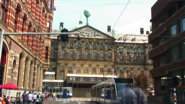 通りに屋根と通勤電車の中でアトラスの像がアムステルダムの王宮のファサード — ストック動画