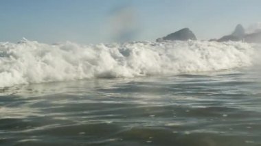 Shore yuvarlanan bir Copacabana dalga statik bir kadeh. Objektif kabarcıklar, geri çeker ve Rio arka planda ortaya kadar ileriye dalga iter.
