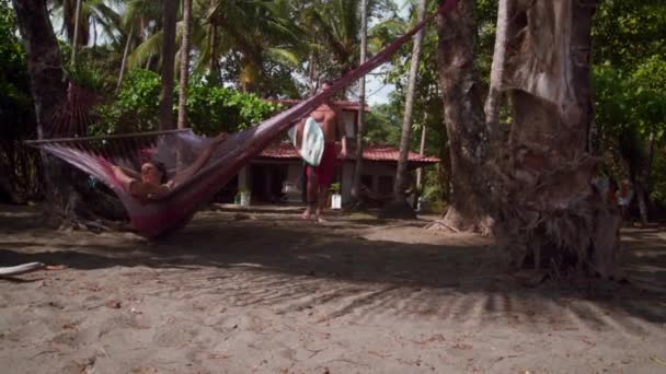 Ember Gazdaság Szörfdeszka Csók Lengő Függőágyban Lelőttek Egy Trópusi Erdőben — Stock videók