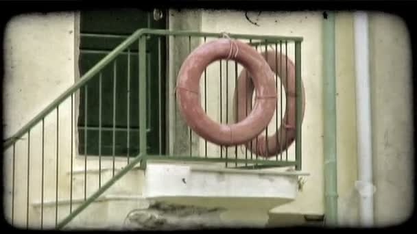 イタリアの玄関口の階段のレールにぶら下がっている つの赤い命の恩人リング ビンテージの様式化されたビデオ クリップ — ストック動画