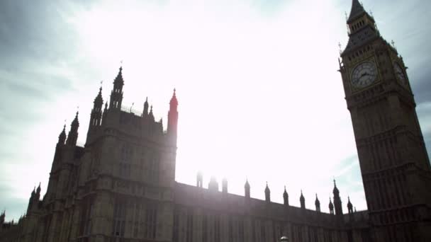 カメラはロンドンのビッグベン時計塔に焦点を当てて 左から右にわずかに移動します 午後に撮影され 太陽が眩しい 興味深い効果を作成します — ストック動画
