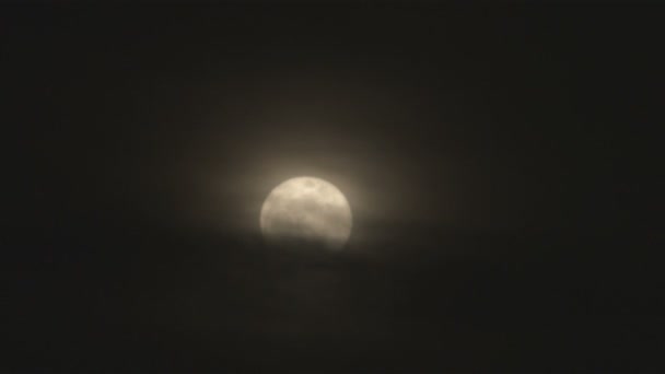 还拍摄的在晚上与温暖的色调和朦胧的阴云覆盖底部一半的满月 — 图库视频影像