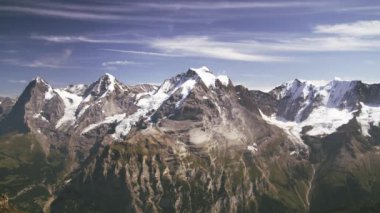 İsviçre Alpleri 'nin geniş açılı görüntüsü. Alpler 'in tepesi karla kaplı. SKy hareket eden beyaz bulutlarla dolu. Sis dağın tepelerinden yükseliyor..