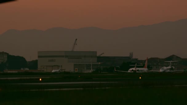 商業飛行機の着陸でリオ ジャネイロ ブラジルのリオ ジャネイロ ブラジル 2013 静的なショット バック グラウンドで駐機場にタキシング他の航空機を見ることができます — ストック動画