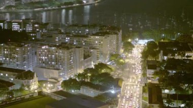 Rio de Janeiro, Brezilya'da yoğun bir karayolu gece hızlandırılmış. Arka planda okyanus ile sokak ve şehir manzarası panoramik görünümü.