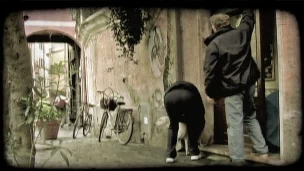 一个男人和女人离开那儿的商店与他们的狗 关了门 门在意大利 复古风格化视频剪辑 — 图库视频影像
