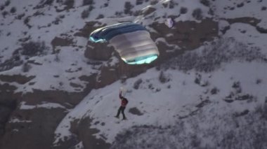 Açık olukla havada süzülen baz atlayıcısının yavaş çekim atışı. Kışın çekildi.