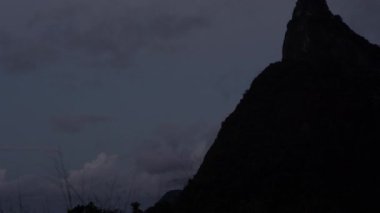 Bir yukarı doğru kaydırma Corcovado Rio de Janeiro, Brezilya için üzerine İsa heykelinin vurdu. Gökyüzü karanlık ve dağ kontrast. İsa heykeli birkaç ışık tarafından aydınlatılmış.
