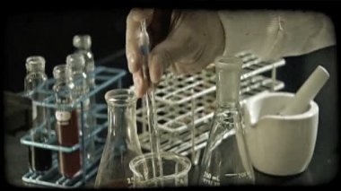 Yeşil bir kimyasal bir kabı çekin ve dışarı başka uzun boylu kabı bücür, arka plan raf şırıngada değiştirmek ve uzun boylu kabı'nın kimyasallar birlikte mix şırınga kullandığından elini yakın çekim