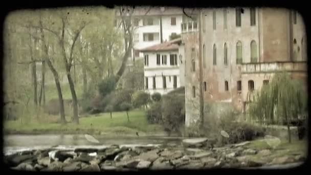 イタリアの川の側面に沿う住宅のショット ビンテージの様式化されたビデオ クリップ — ストック動画