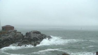 Sisli ve yağışlı deniz manzarası Cape Elizabeth, Maine Portland Head ışık arasında pan.